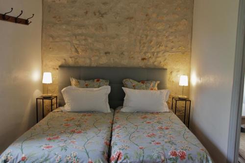 a bed in a bedroom with two lamps on both sides at Grange Bleuet in Aubeterre-sur-Dronne