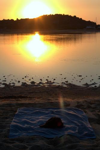 a blanket on the beach with the sunset in the background at Livari Studios in Vourvourou