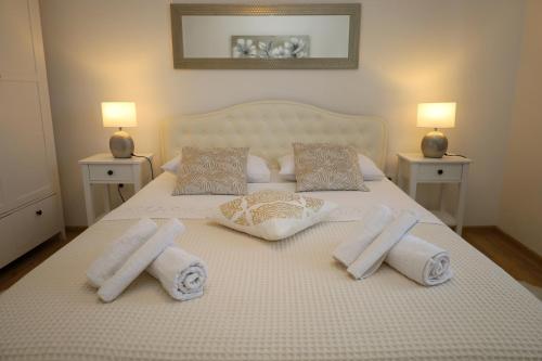 a white bed with towels and pillows on it at Holiday house Nono in Sumartin