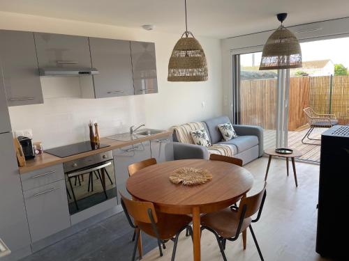une cuisine et un salon avec une table et un canapé dans l'établissement Maison de Vacances 2 personnes, ossature bois, à Saint Gilles Croix De Vie 85, à Saint-Gilles-Croix-de-Vie