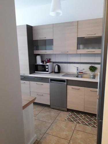 a kitchen with a sink and a microwave at Sloneczny apartament w Giżycku in Giżycko