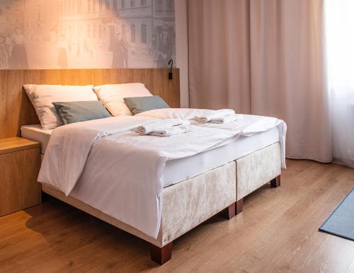 a bed with white sheets and towels on it at Beseda in České Budějovice