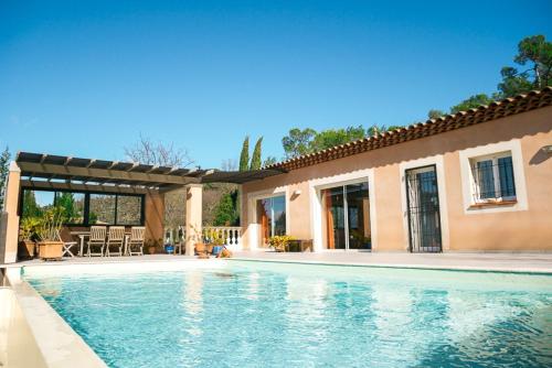 une piscine devant une maison dans l'établissement Superbe villa 150 m2 plain pied climatisée avec piscine, à Rocbaron