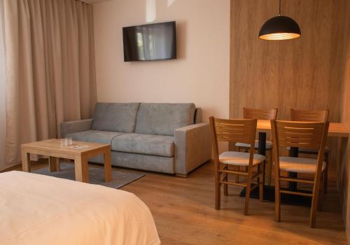 um quarto de hotel com um sofá, uma mesa e cadeiras em Beseda em České Budějovice