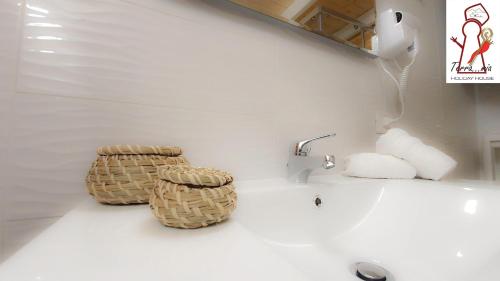 - Baño con lavamanos y 2 cestas en Terramia Holiday House, en Nápoles