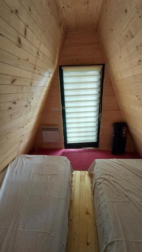 a attic room with two beds and a window at Natural Cottage Glamping Eco-Tiny House in Škocjan