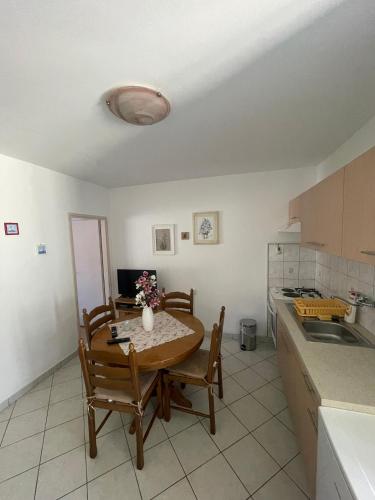 a kitchen with a table and chairs and a sink at Apartments Pecotić in Brna
