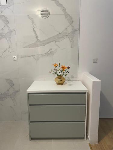a dresser with a vase of flowers on top of it at Six bedroom Holiday home Matea in Ploče