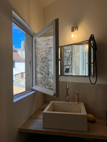 La salle de bains est pourvue d'un lavabo en face d'une fenêtre. dans l'établissement Penthouse Apartment with Large Terrace and Veranda, à Arles