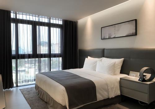 a bedroom with a large bed and a large window at M Hotel Saigon in Ho Chi Minh City