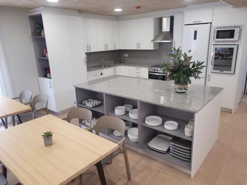 a kitchen with white cabinets and a table and a counter at Malva Hostel in L'Estartit