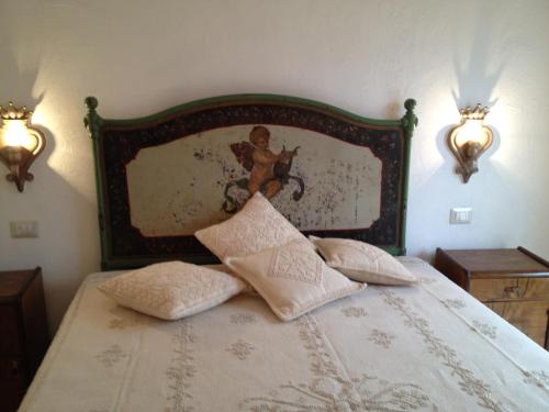 a bedroom with a bed with a painting on the wall at Antica Dimora La Corona in San Pantaleo
