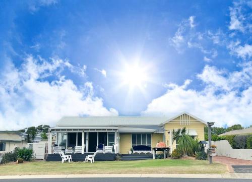 a yellow house with the sun in the sky at The Cove Cottage in Pemberton