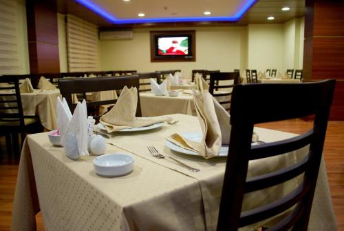 a dining room with tables and chairs with white table cloth at Lifos Hotel in Kayseri