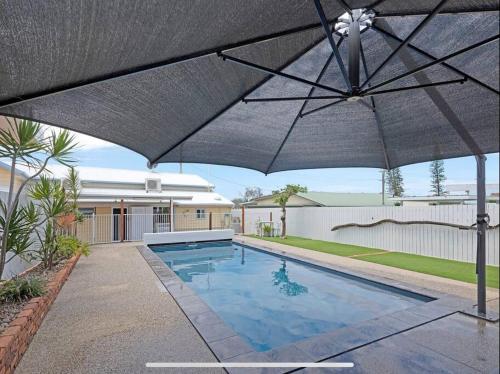 an umbrella over a swimming pool in a yard at The Cove Cottage in Pemberton