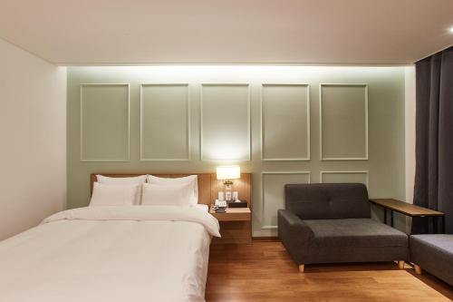 a hotel room with a bed and a chair at Hotel the maru in Pyeongchang 