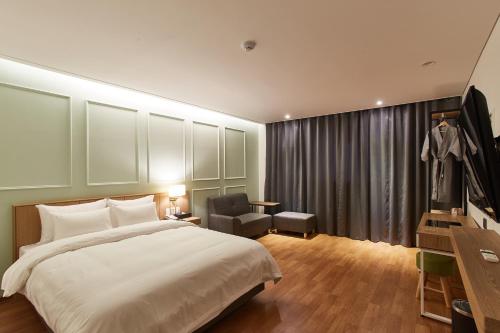 a bedroom with a bed and a desk and a chair at Hotel the maru in Pyeongchang 