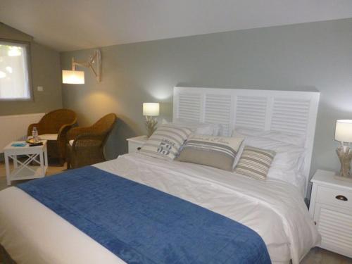 a bedroom with a large white bed with pillows at Le Clos du miroir in Courset