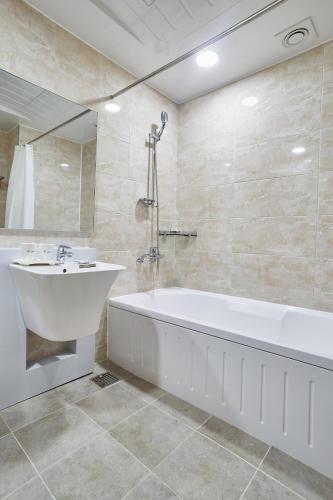 a bathroom with a white tub and a sink at Hotel the maru in Pyeongchang 