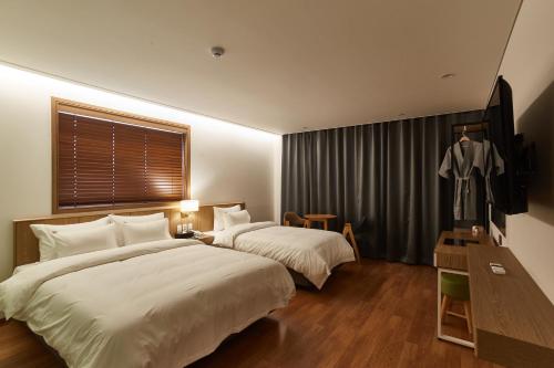 a hotel room with two beds and a window at Hotel the maru in Pyeongchang 