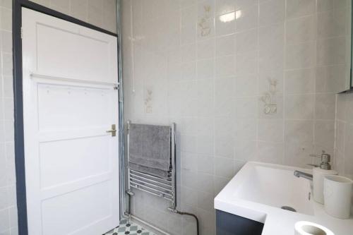 y baño blanco con lavabo y ducha. en A stylish four bedroom house in wollaton, en Nottingham