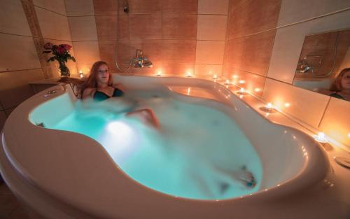 a woman in a bath tub with lights in it at Hotel Slovan in Jeseník