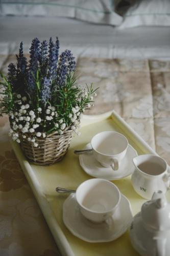 a tray with two tea cups and a basket of flowers at Villa Necchi alla Portalupa in Gambolò
