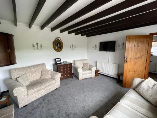 ein Wohnzimmer mit 2 Sofas und einem TV in der Unterkunft Dove Cottage - Stay at Gwens in Buxton