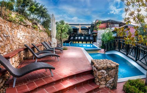 a patio with chairs next to a swimming pool at Kallisti Hotel in Potos