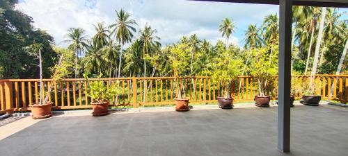 a balcony with potted plants and a wooden fence at Le Grand Bleu Hotel in Wok Tum