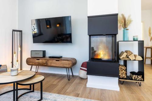 sala de estar con chimenea y mesa en Haus "Hygge" mit Kamin, Sauna, Whirpool, Garten OFC 19, en Pepelow