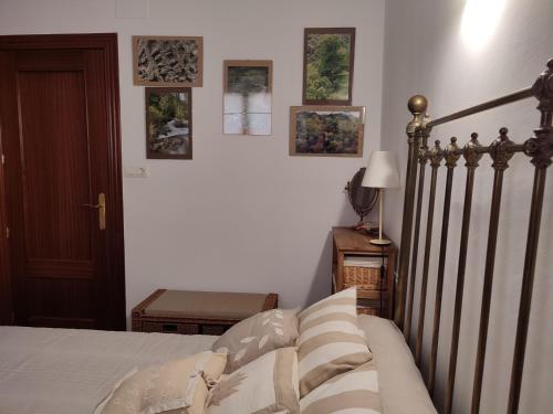 a bedroom with a bed and some pictures on the wall at La Launa apartamento rural in Trevélez