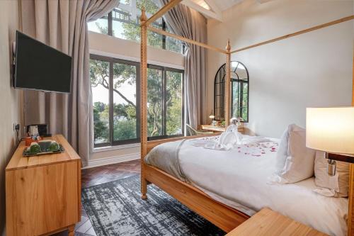 a bedroom with a bed and a large window at Palm River Hotel in Victoria Falls