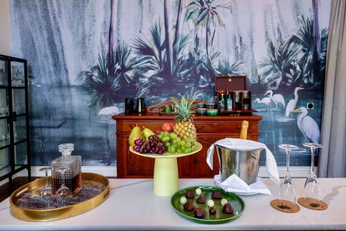 a table with a plate of fruit and a bowl of pineapple at Palm River Hotel in Victoria Falls