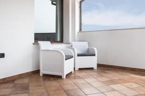 two wicker chairs sitting in a room with a window at Residenze Branca III SeaView in Orosei