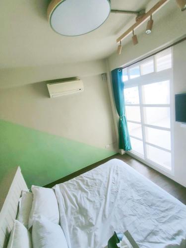 a small bedroom with a bed and a window at 冬映Winn 愛毛孩包棟民宿l寵物友善l不限時歡唱KTV in Wujie