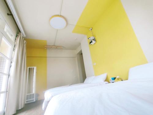 a bedroom with two beds and a yellow wall at 冬映Winn 愛毛孩包棟民宿l寵物友善l不限時歡唱KTV in Wujie