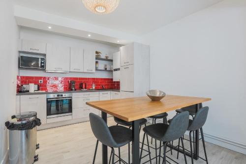 a kitchen with a wooden table and chairs at La Halte de Saint-Pierre in Clermont-Ferrand
