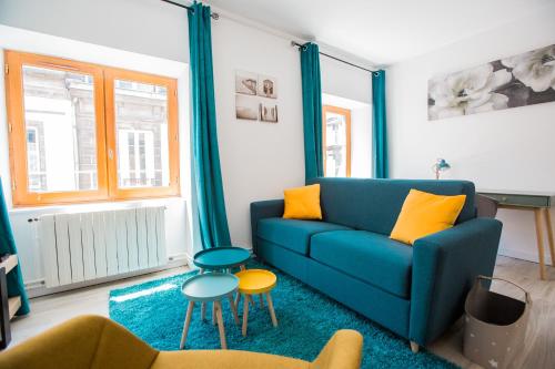 a living room with a blue couch and yellow pillows at La Halte de Saint-Pierre in Clermont-Ferrand