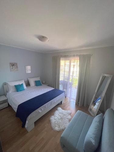 a bedroom with a large bed and a couch at Apartments Pecotić in Brna