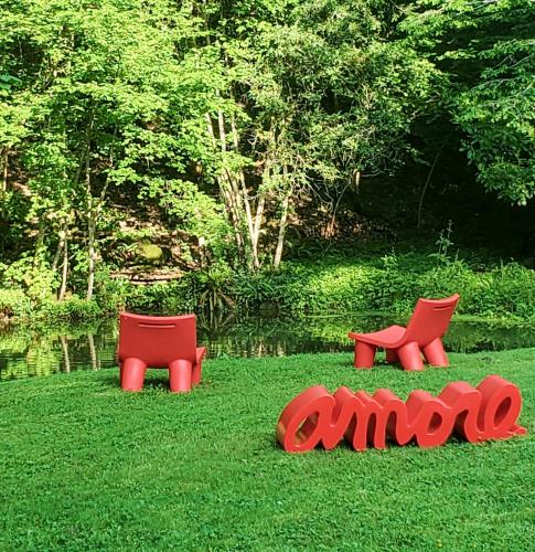 two red chairs sitting in the grass in a field at Domaine du Val Sauvage in Langeais