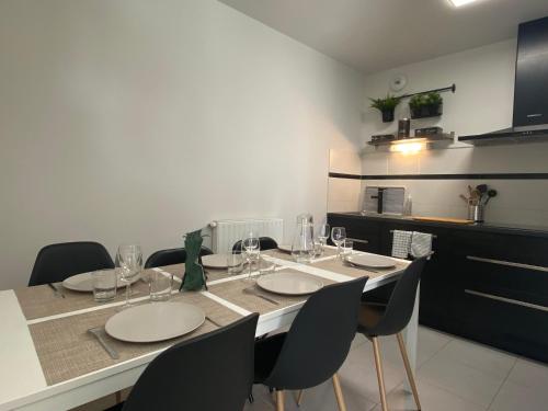 uma mesa de jantar com cadeiras e copos de vinho em Appartement familial tout confort - 3 chambres, grande terrasse privative - Vert Buisson - Bruz em Bruz