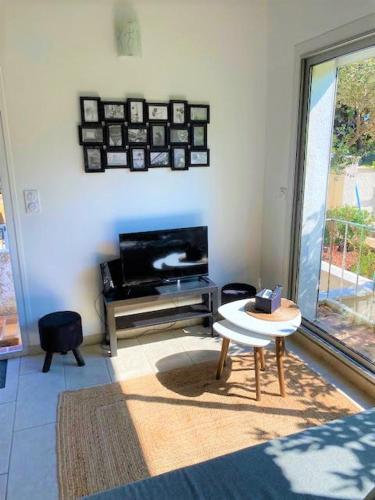un salon avec une table et une télévision dans l'établissement VILLA BELLA I, à La Seyne-sur-Mer
