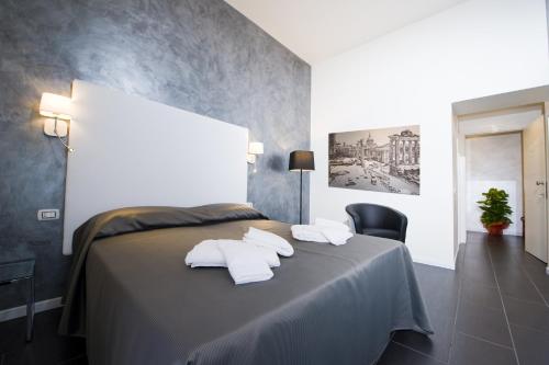 una camera da letto con un letto e asciugamani pieghevoli di Grey&White a Roma