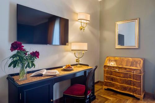 a room with a desk, chair, lamp and a mirror at Grand Hotel Villa Politi in Syracuse