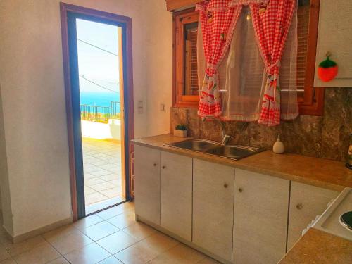 a kitchen with a sink and a view of the ocean at house with sea and mountain view in Rozená