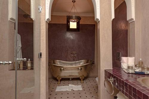 a bathroom with a tub and a sink at Palais El Roucar in Marrakesh