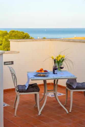 a table and two chairs with a table and flowers at Grand Hotel Villa Politi in Siracusa