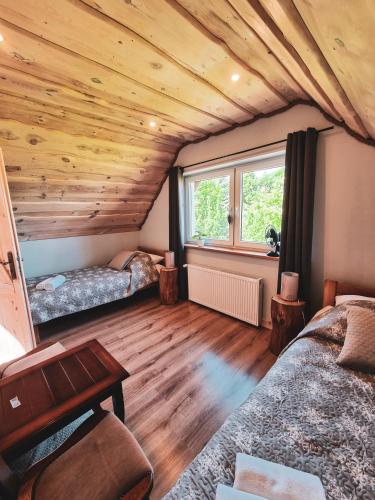 a bedroom with two beds and a wooden ceiling at Domek Drwala k. Karpacza in Sosnówka