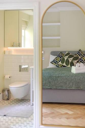 a bedroom with a bed and a tub and a mirror at Stunning Two Bed Apartment RH8 in London